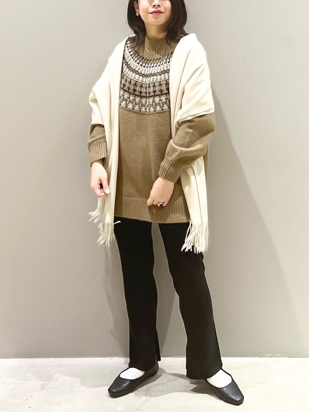 ブラック系のその他パンツ、ブラック系のパンプス、ホワイト系のストール/ショールを着用したレディースの秋コーディネートの4枚目の写真