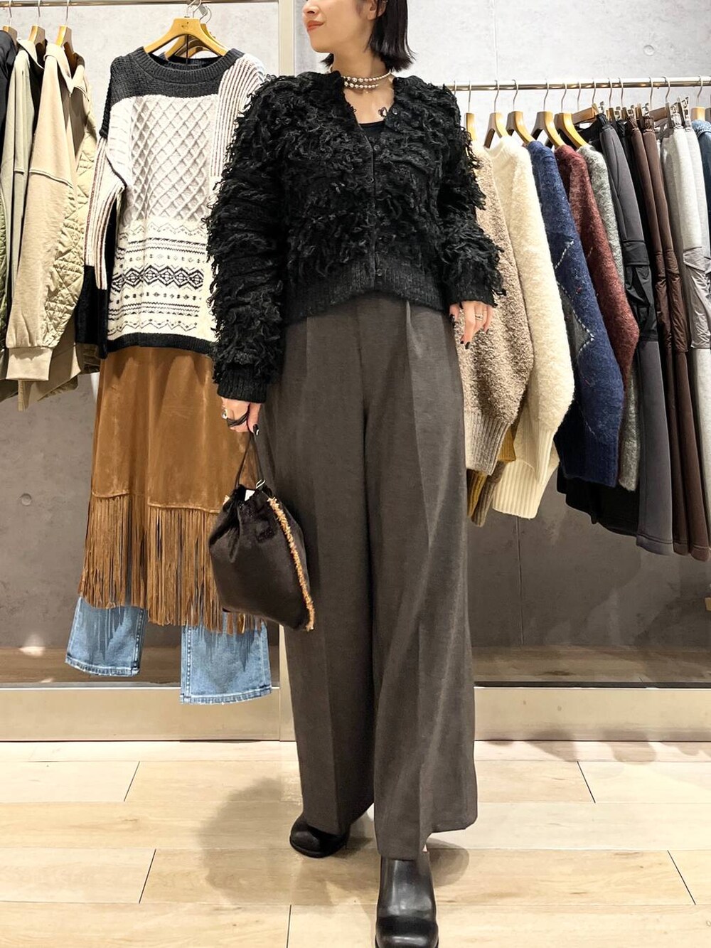 ブラック系のその他シューズ、グレー系のその他パンツ、ブラウン系のショルダーバッグを着用したレディースの秋コーディネートの5枚目の写真