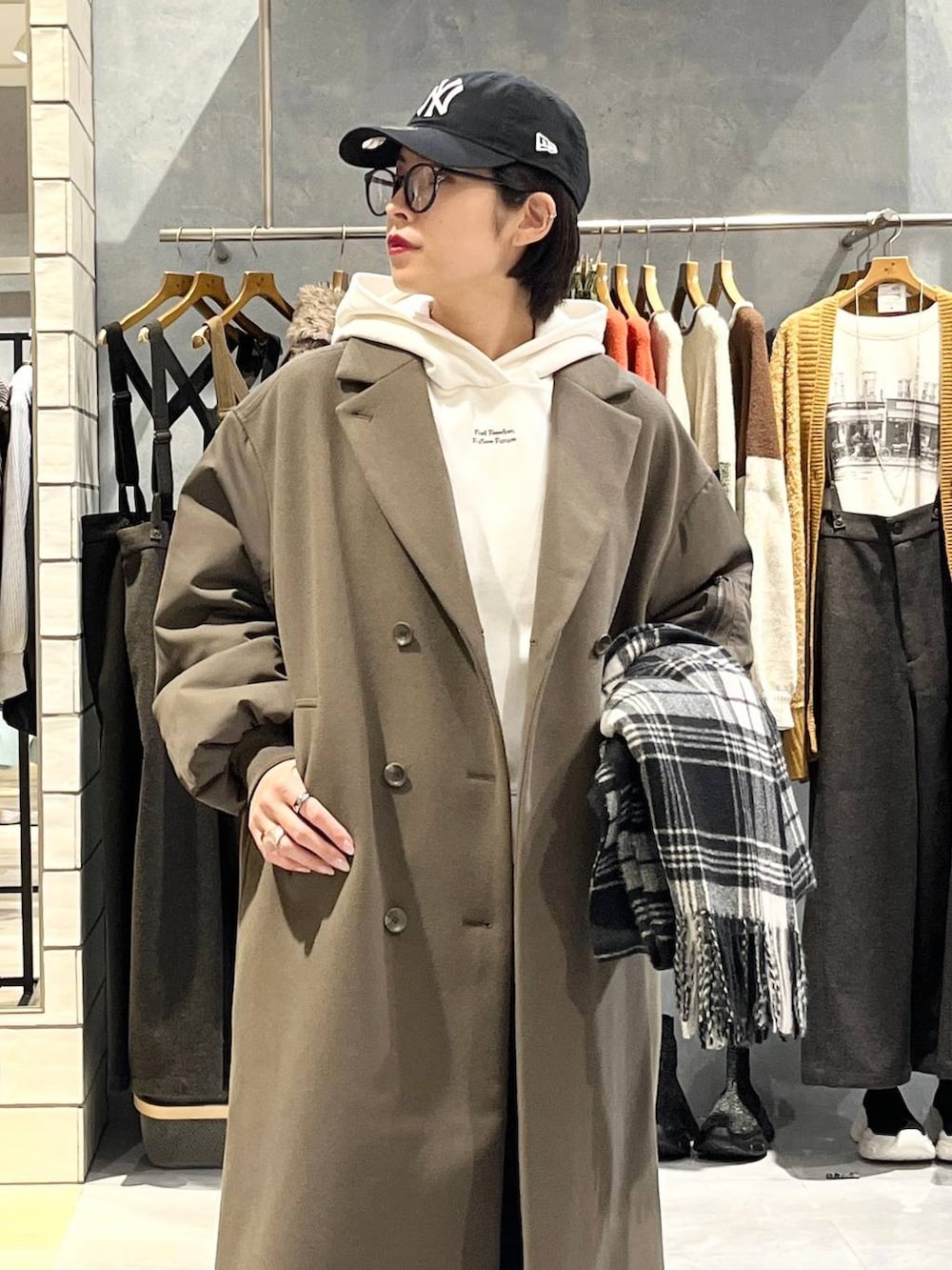 ブラウン系のスニーカー、ホワイト系のパーカー、ブラウン系のその他アウターを着用したレディースの秋コーディネートの4枚目の写真