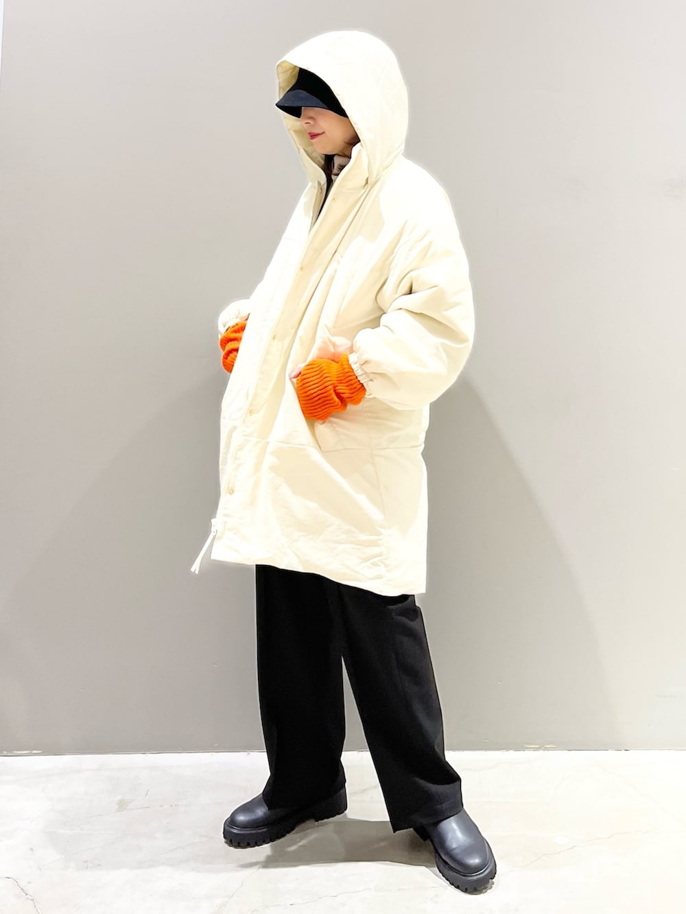 ブラウン系のニット/セーター、ホワイト系のジャケット/アウター、ブラック系のパンツを着用したレディースの冬コーディネートの5枚目の写真