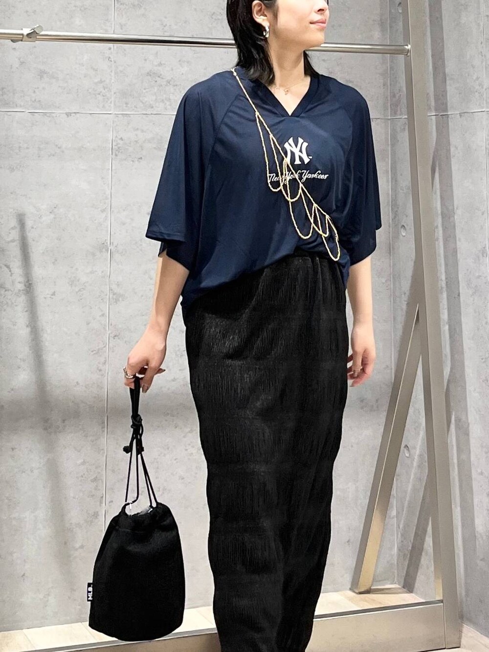 ブラック系のサンダル、ブラック系のスカート、ホワイト系のTシャツ/カットソーを着用したレディースの夏コーディネートの5枚目の写真