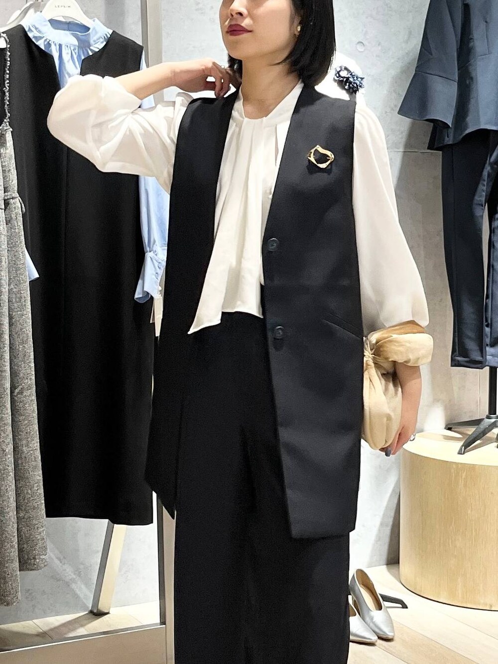 ベージュ系のハンドバッグ、ホワイト系のシャツ/ブラウス、ブラック系のパンプスを着用したレディースの冬コーディネートの7枚目の写真