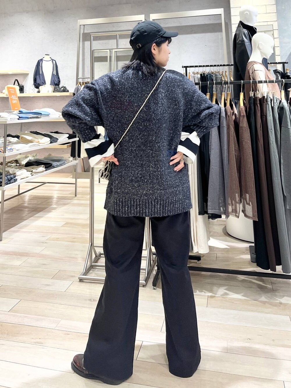 シルバー系のショルダーバッグ、グレー系のチノパンツ、ブラック系のTシャツ/カットソーを着用したレディースの秋コーディネートの4枚目の写真