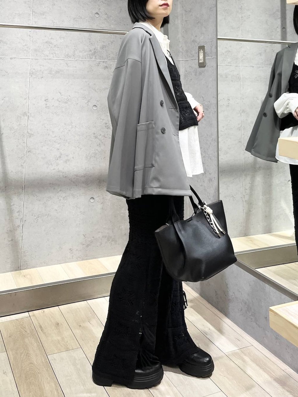 ブラック系のブーツ、ホワイト系のシャツ/ブラウス、グレー系のテーラードジャケットを着用したレディースの冬コーディネートの2枚目の写真
