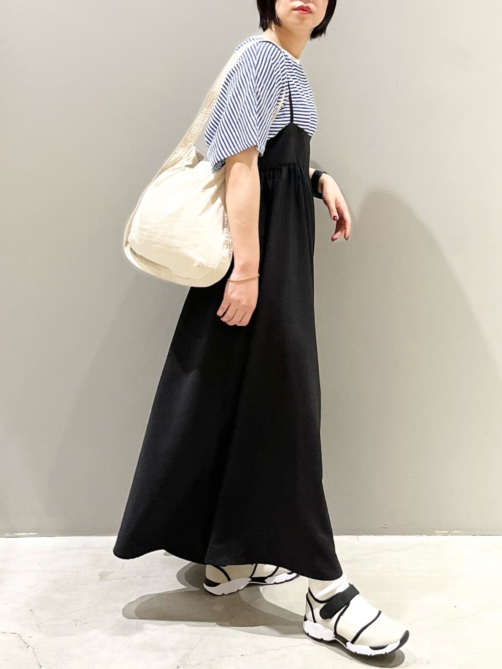 ブラック系のワンピース、ブルー系のTシャツ/カットソー、ホワイト系のショルダーバッグを着用したレディースの秋コーディネートの5枚目の写真