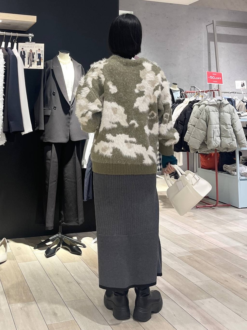 ブラック系のニット/セーター、ブラック系のスカート、ブラック系のブーツを着用したレディースの冬コーディネートの6枚目の写真