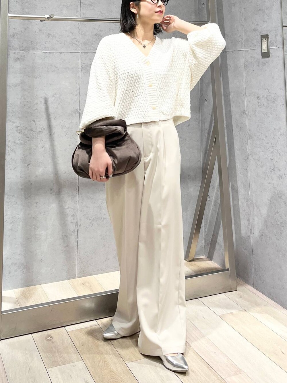 ブラウン系のハンドバッグ、グレー系のパンプス、ホワイト系のカーディガン/ボレロを着用したレディースの冬コーディネートの7枚目の写真