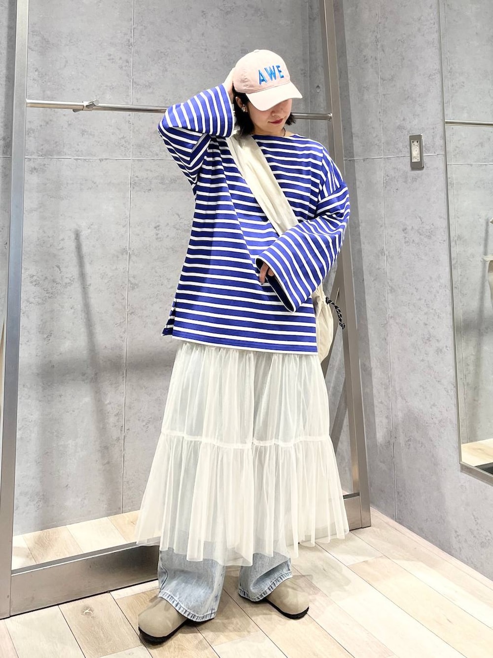 ホワイト系のスカート、パープル系のTシャツ/カットソー、ブルー系のデニムパンツを着用したレディースの冬コーディネートの6枚目の写真