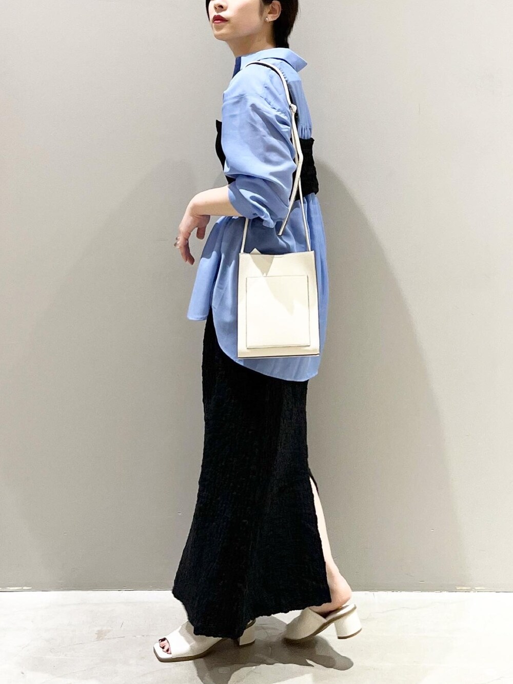 ホワイト系のサンダル、ブラック系のスカート、ブルー系のシャツ/ブラウスを着用したレディースの春コーディネートの4枚目の写真