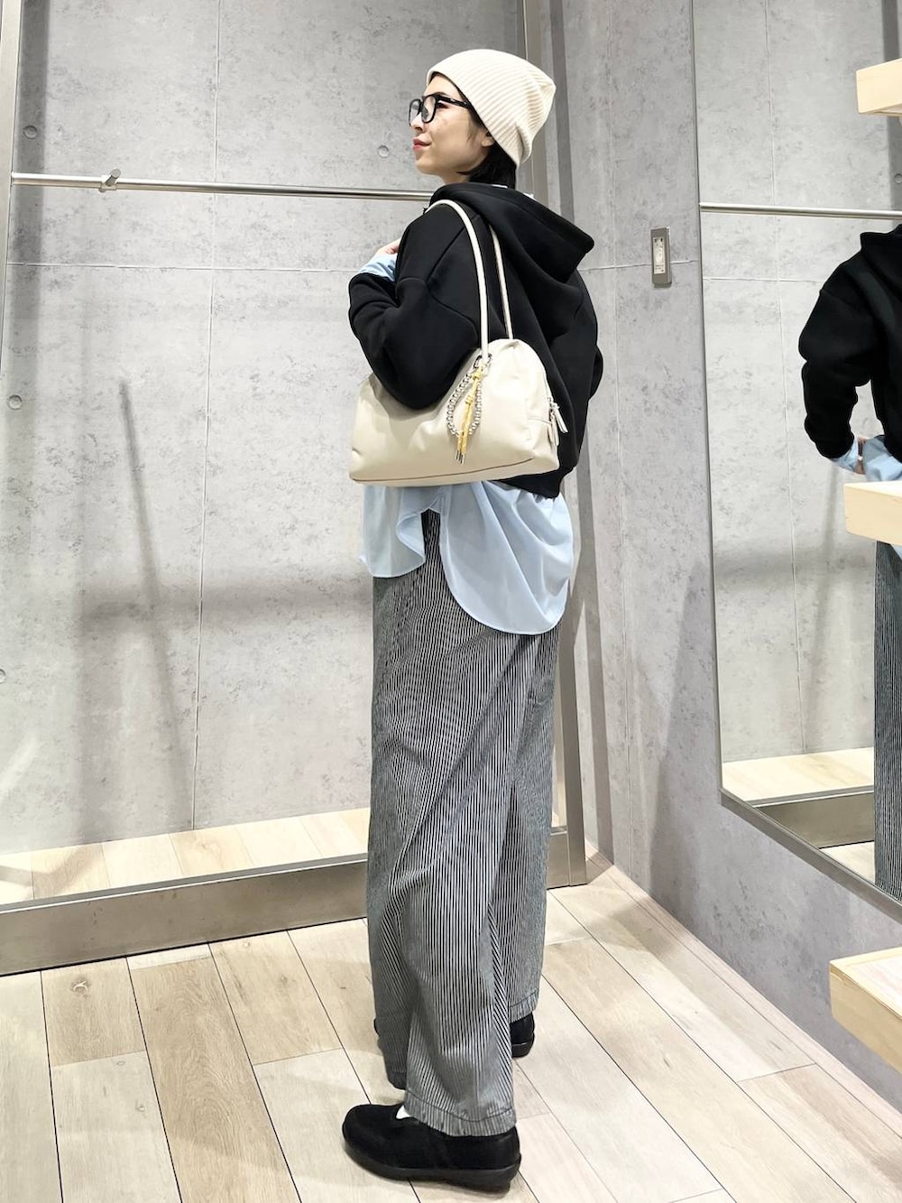 ブルー系のシャツ/ブラウス、ブラック系のボストンバッグ、ブラック系のパンプスを着用したレディースの冬コーディネートの3枚目の写真