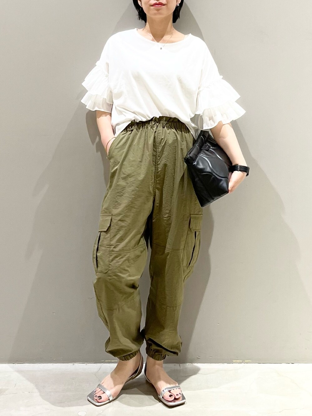 シルバー系のサンダル、ブラック系のバッグ、ホワイト系のTシャツ/カットソーを着用したレディースの秋コーディネートの3枚目の写真