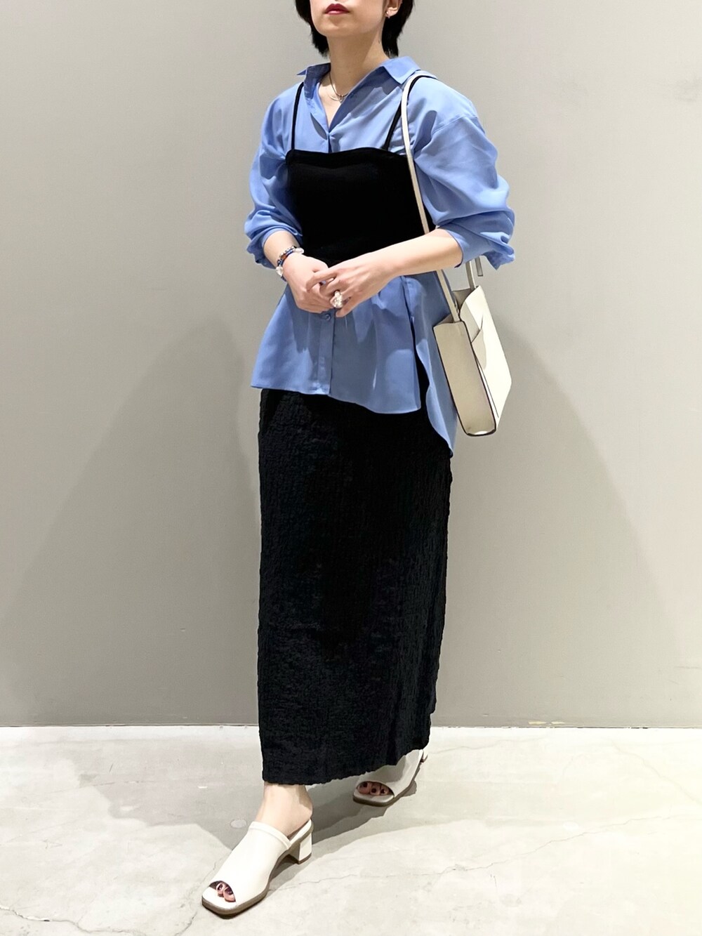 ホワイト系のサンダル、ブラック系のスカート、ブルー系のシャツ/ブラウスを着用したレディースの春コーディネートの6枚目の写真