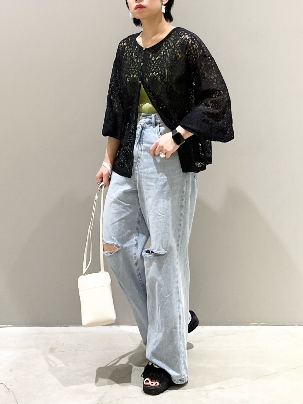 ブラック系のシャツ/ブラウス、ブルー系のデニムパンツ、ブラック系のサンダルを着用したレディースの秋コーディネートの3枚目の写真