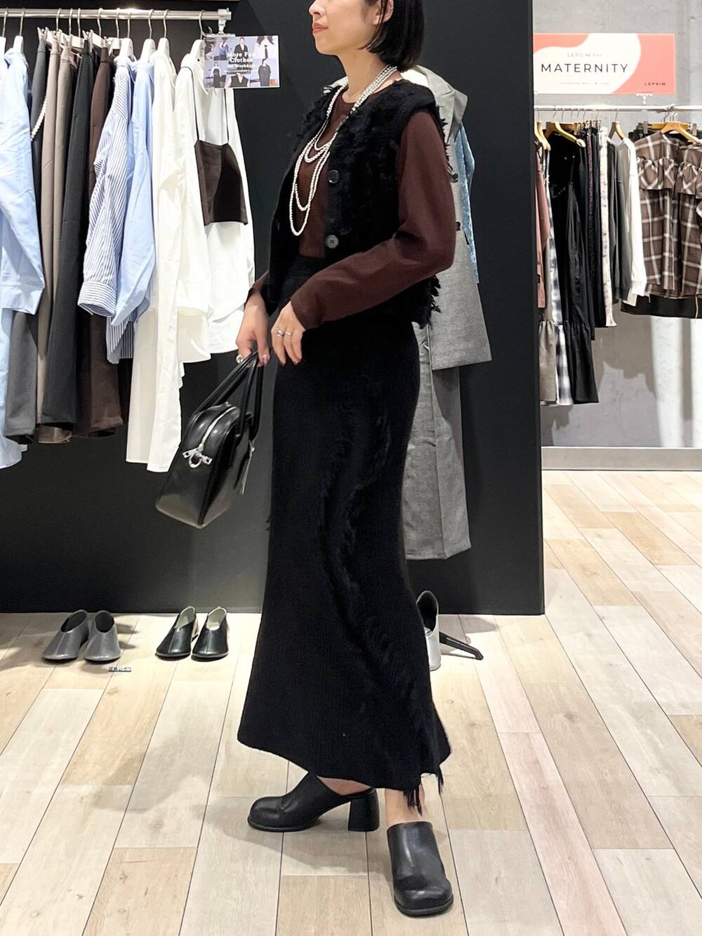 ブラック系のその他シューズ、ブラック系のボストンバッグ、ブラウン系のTシャツ/カットソーを着用したレディースの秋コーディネートの3枚目の写真