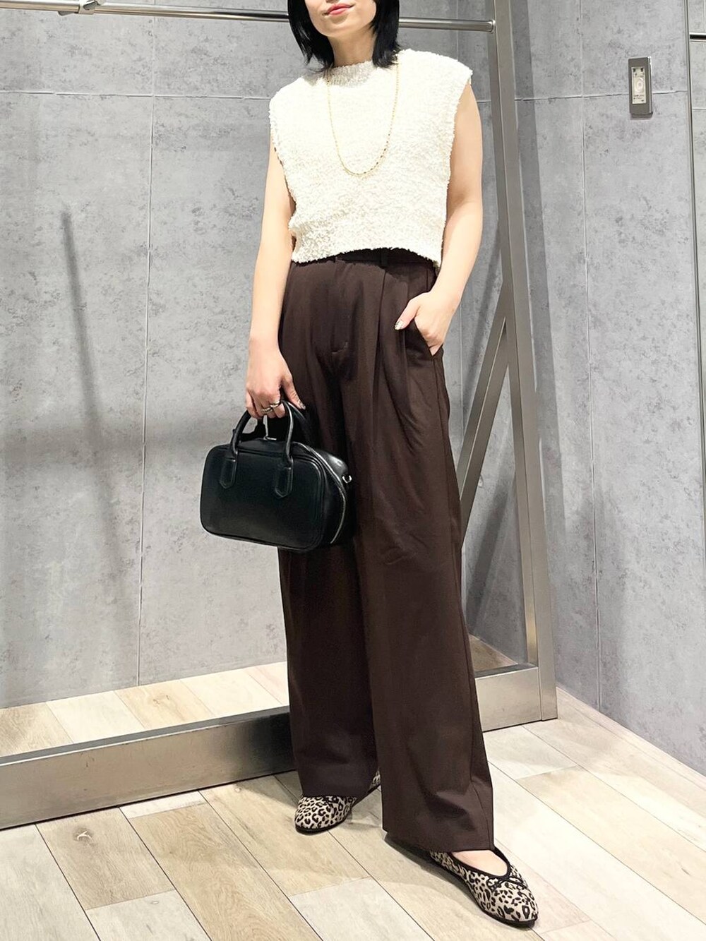 ブラック系のボストンバッグ、その他のバレエシューズ、ホワイト系のベストを着用したレディースの秋コーディネートの3枚目の写真