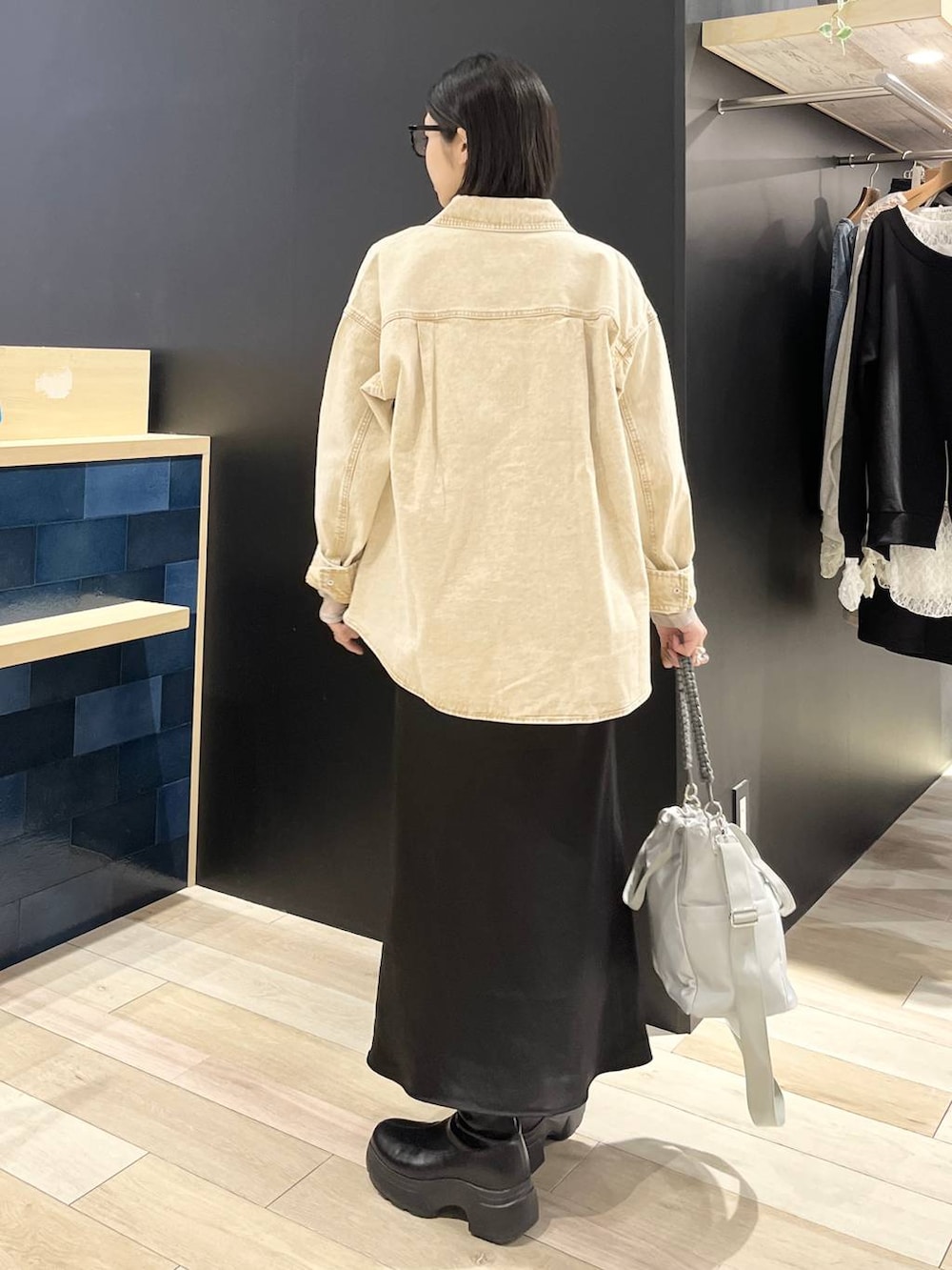 ブラック系のTシャツ/カットソー、ブラック系のスカート、ブラック系のブーツを着用したレディースの春コーディネートの5枚目の写真