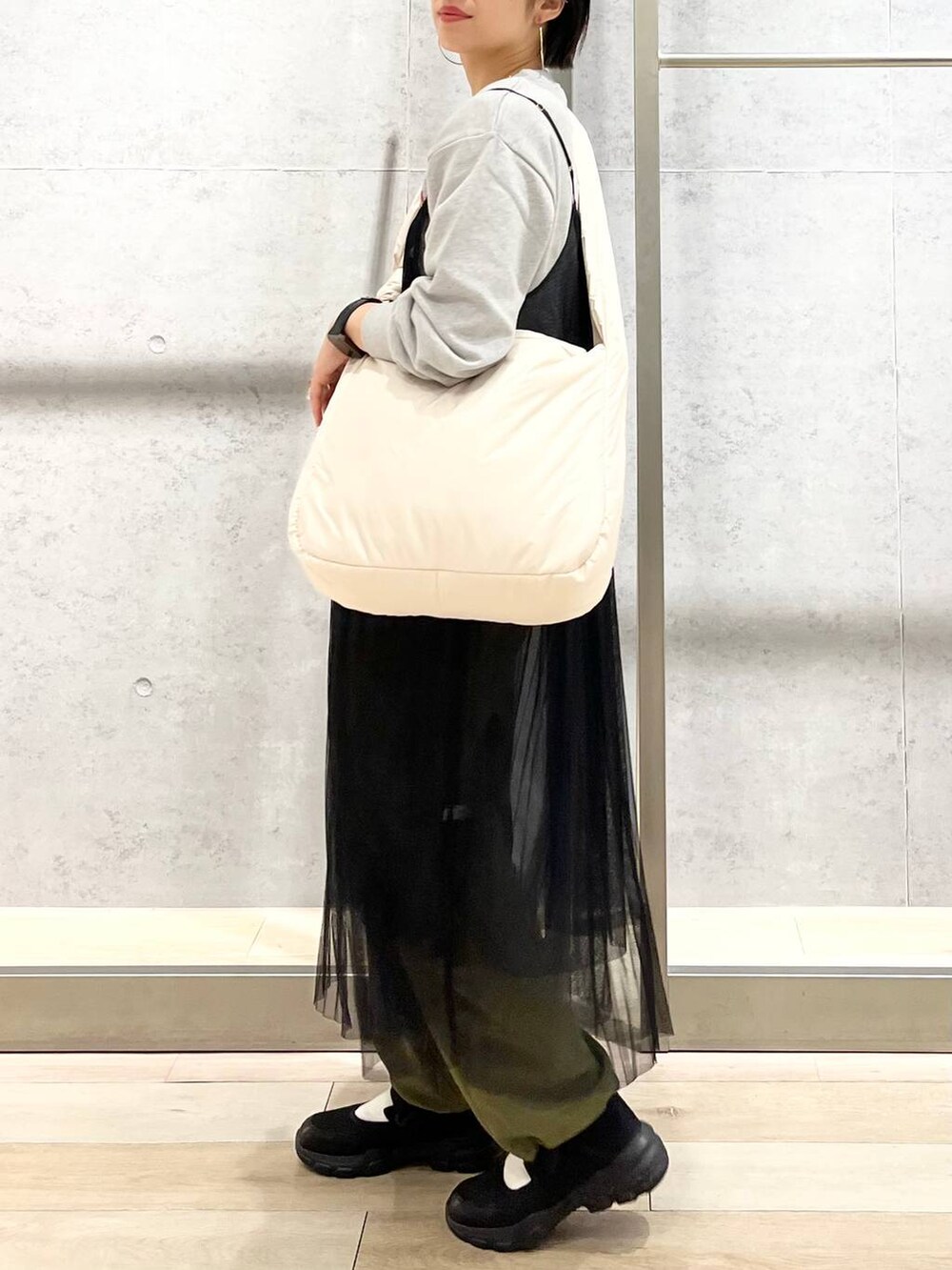 グレー系のスウェット、ブラック系のスニーカー、グリーン系のカーゴパンツを着用したレディースの秋コーディネートの3枚目の写真