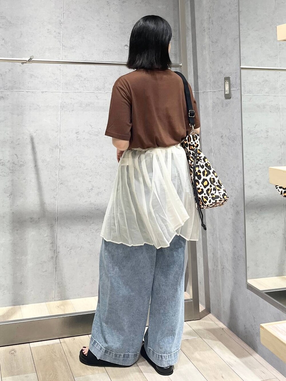 ブルー系のデニムパンツ、ブラック系のサンダル、シルバー系のネックレスを着用したレディースの夏コーディネートの5枚目の写真