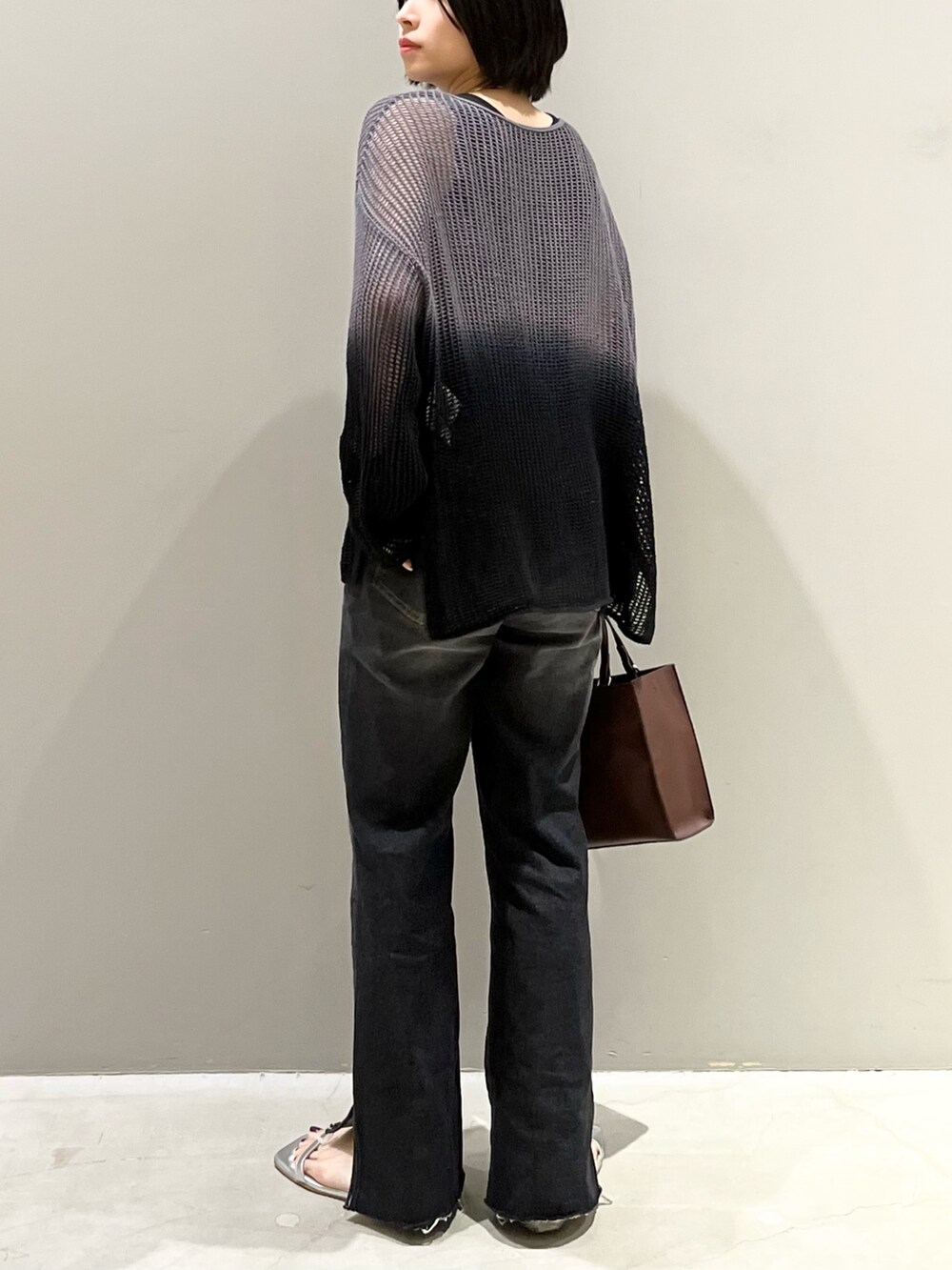 ブラック系のデニムパンツ、ブラウン系のバッグ、シルバー系のサンダルを着用したレディースの夏コーディネートの6枚目の写真