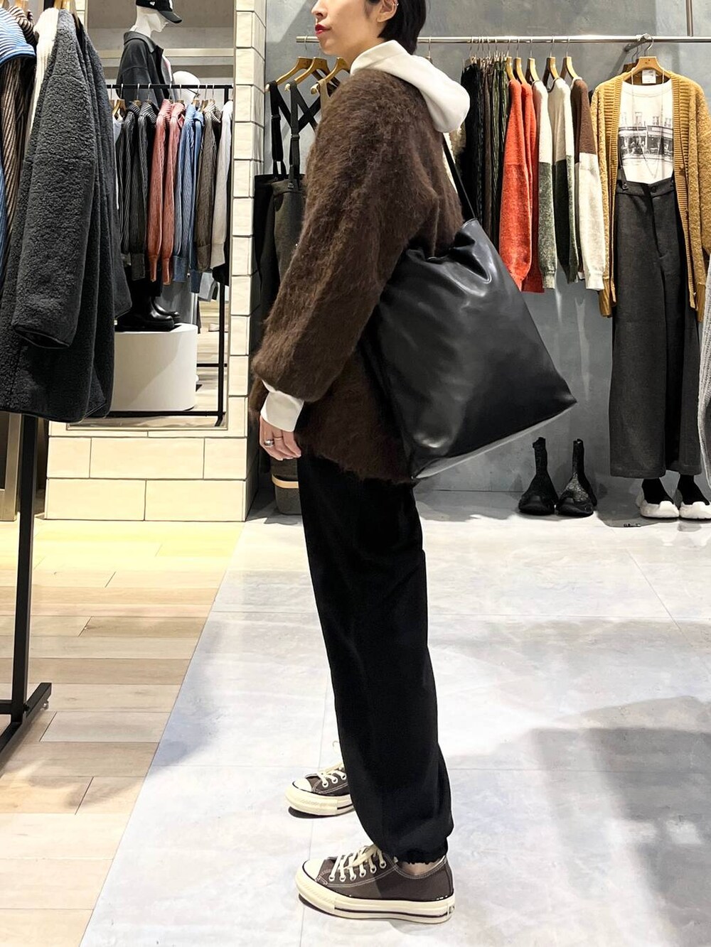 ブラウン系のスニーカー、ブラック系のその他パンツ、ブラウン系のカーディガン/ボレロを着用したレディースの秋コーディネートの3枚目の写真