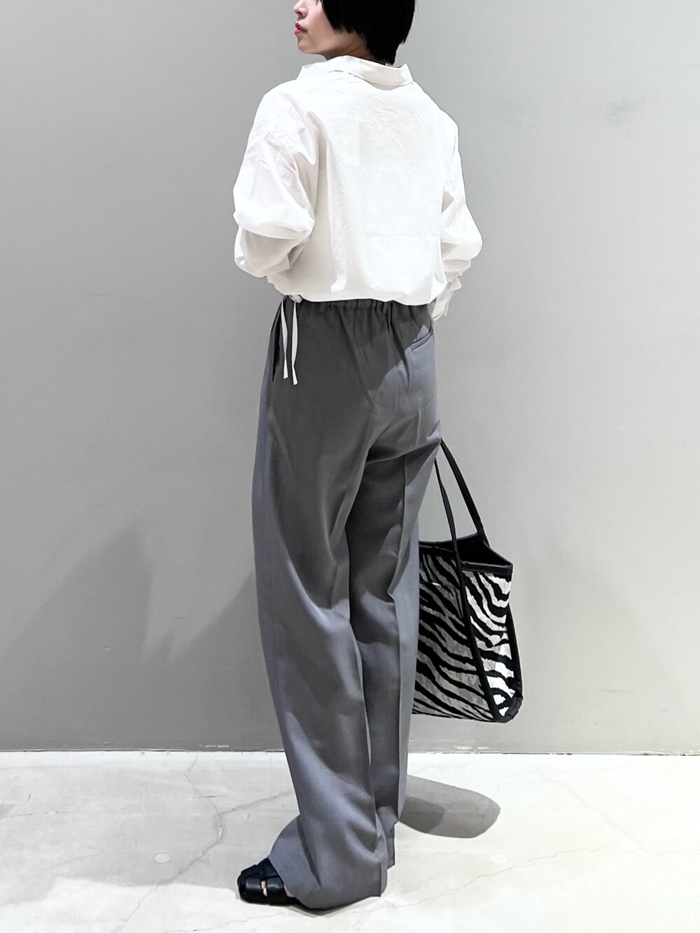 ホワイト系のシャツ/ブラウス、ブラック系のバッグ、グレー系のデニムパンツを着用したレディースの春コーディネートの3枚目の写真