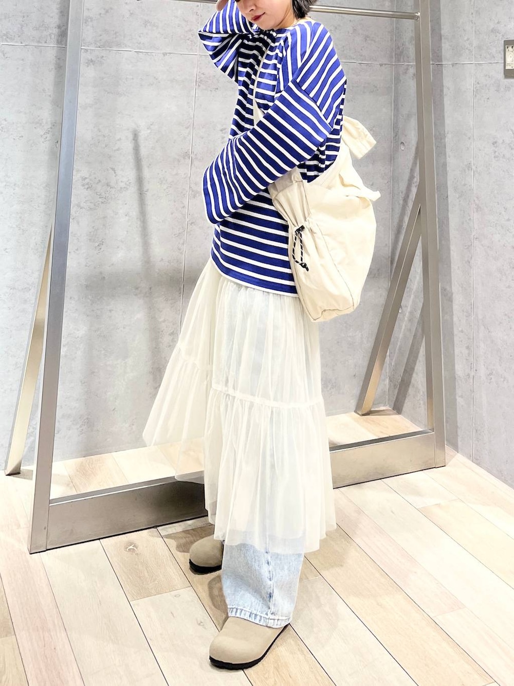 ホワイト系のスカート、パープル系のTシャツ/カットソー、ブルー系のデニムパンツを着用したレディースの冬コーディネートの7枚目の写真