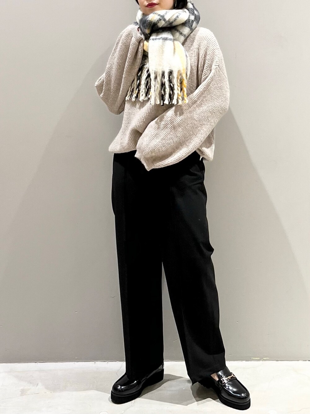 ブラウン系のニット/セーター、ブラック系のローファー、ブラック系のスラックスを着用したレディースの冬コーディネートの2枚目の写真