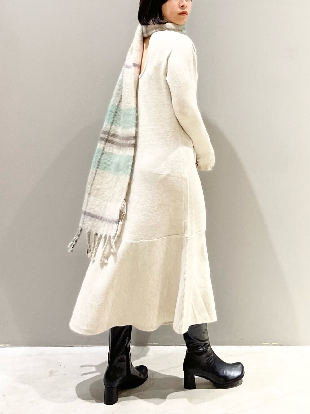 ブラック系のブーツ、ベージュ系のワンピース、ベージュ系のストール/ショールを着用したレディースの冬コーディネートの5枚目の写真