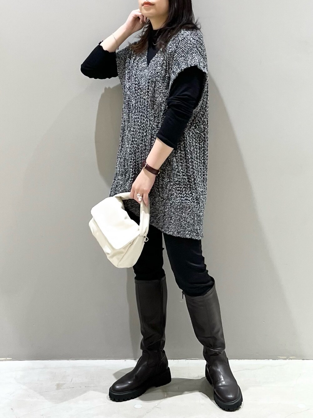 ブラウン系のブーツ、ブラック系のバッグ、ブラック系のその他パンツを着用したレディースの秋コーディネートの5枚目の写真