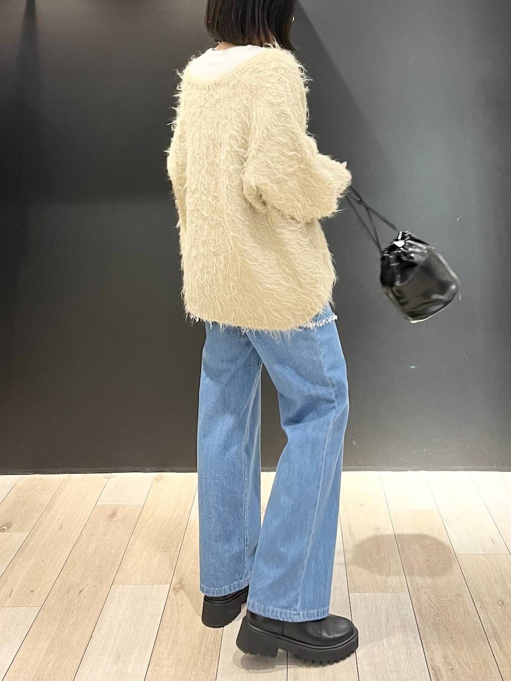 ホワイト系のTシャツ/カットソー、ブラック系のブーツ、ベージュ系のカーディガン/ボレロを着用したレディースの冬コーディネートの3枚目の写真