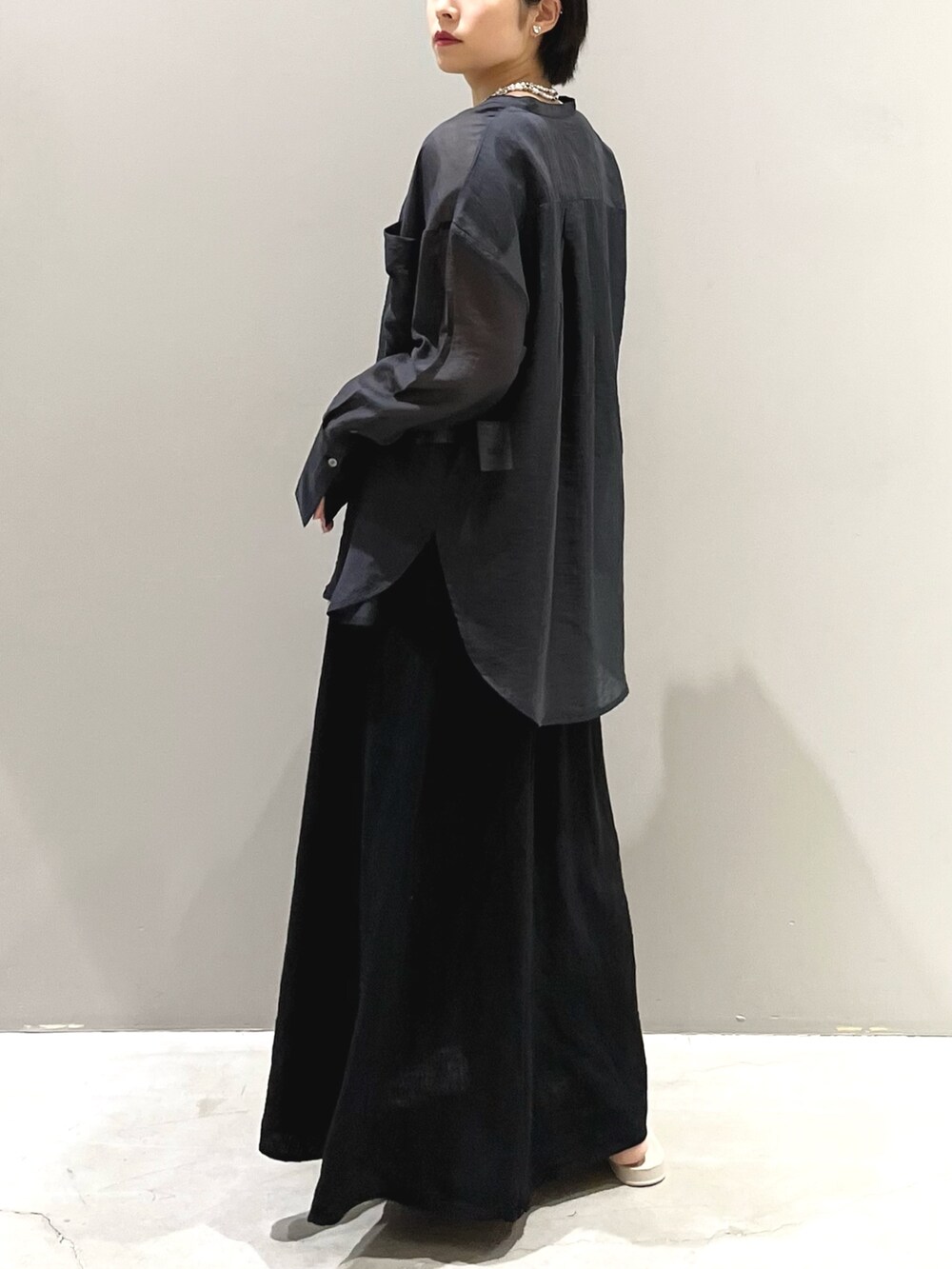 ホワイト系のサンダル、オレンジ系のバッグ、ブラック系のスカートを着用したレディースの夏コーディネートの4枚目の写真