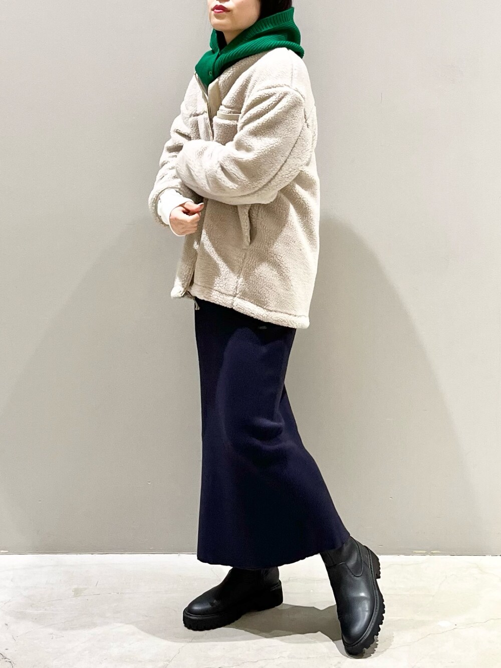 ブルー系のスカート、ブラック系のブーツ、ホワイト系のトップスを着用したレディースの秋コーディネートの3枚目の写真