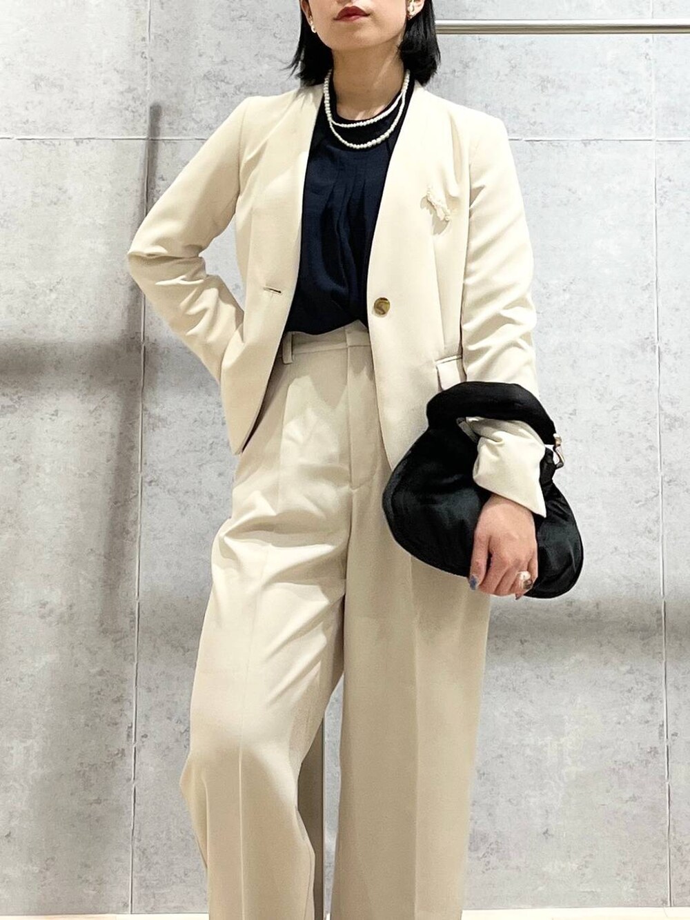 ブラック系のハンドバッグ、ブルー系のシャツ/ブラウス、ホワイト系のノーカラージャケットを着用したレディースの冬コーディネートの7枚目の写真