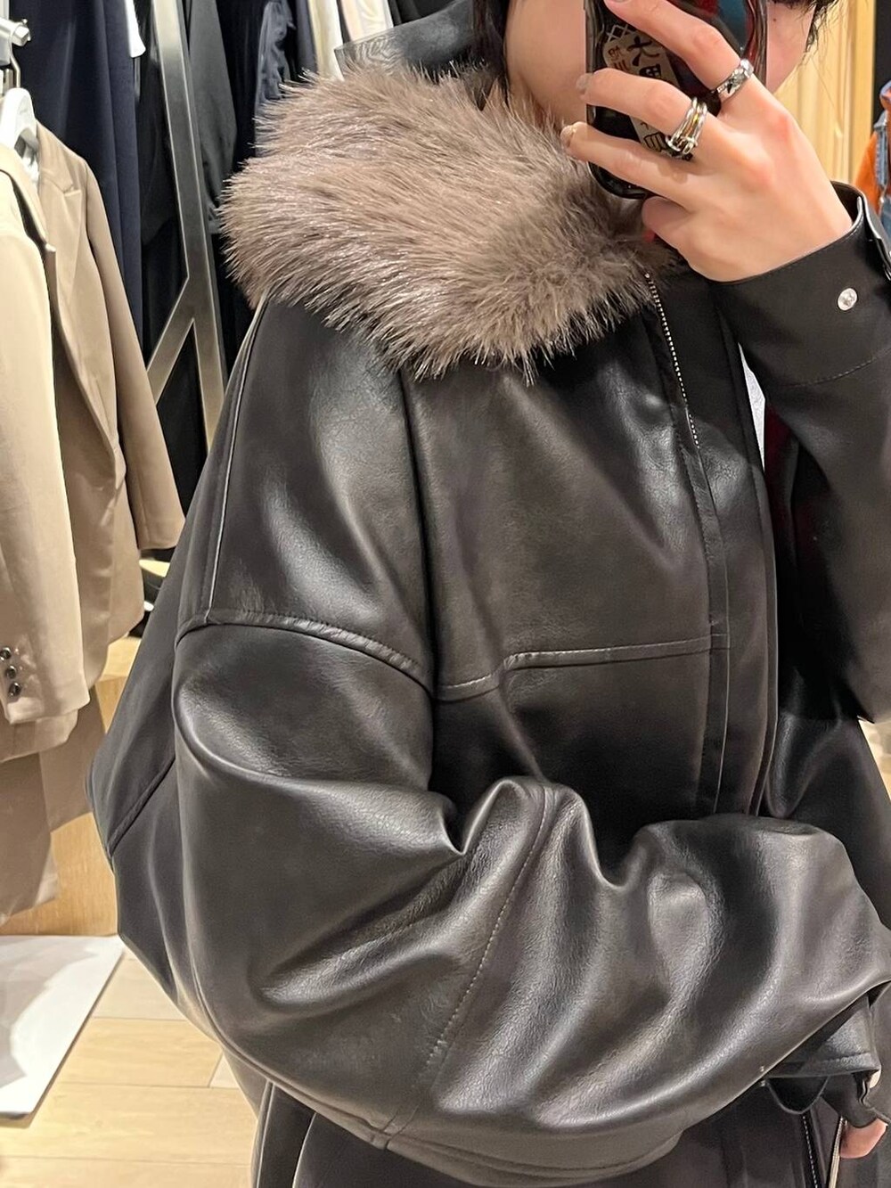 ブラック系のブーツ、オレンジ系のニット/セーター、ブラック系のスカートを着用したレディースの冬コーディネートの8枚目の写真