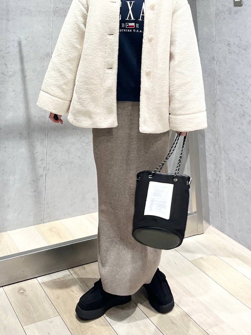 ブルー系のTシャツ/カットソー、ホワイト系のブルゾン、ブラック系のモカシン/デッキシューズを着用したレディースの秋コーディネートの7枚目の写真