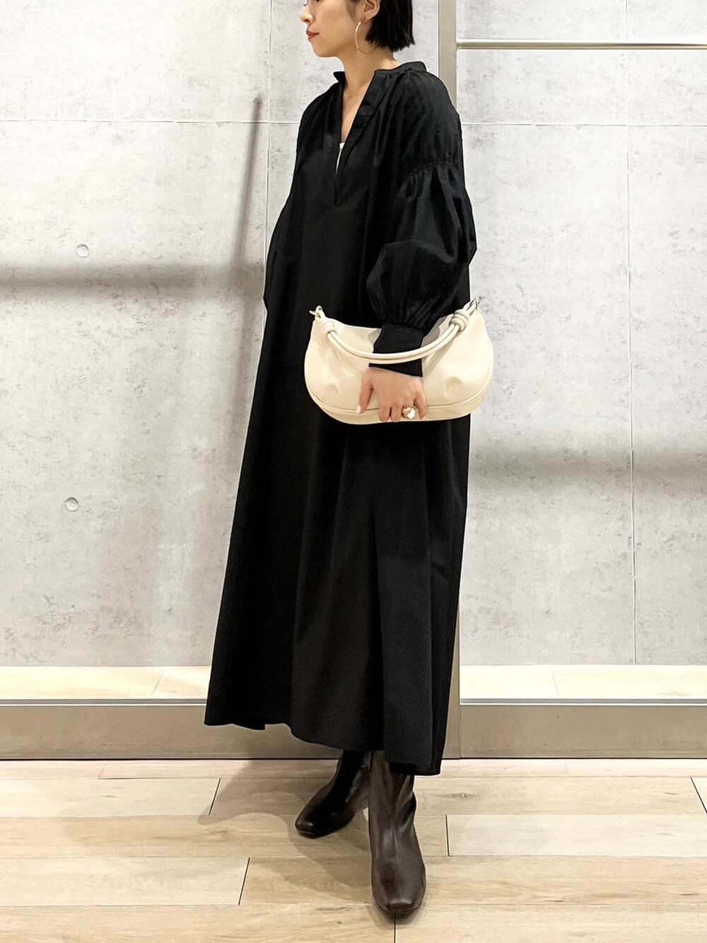 ホワイト系のキャミソール、ブラック系のワンピース、ホワイト系のショルダーバッグを着用したレディースの秋コーディネートの7枚目の写真