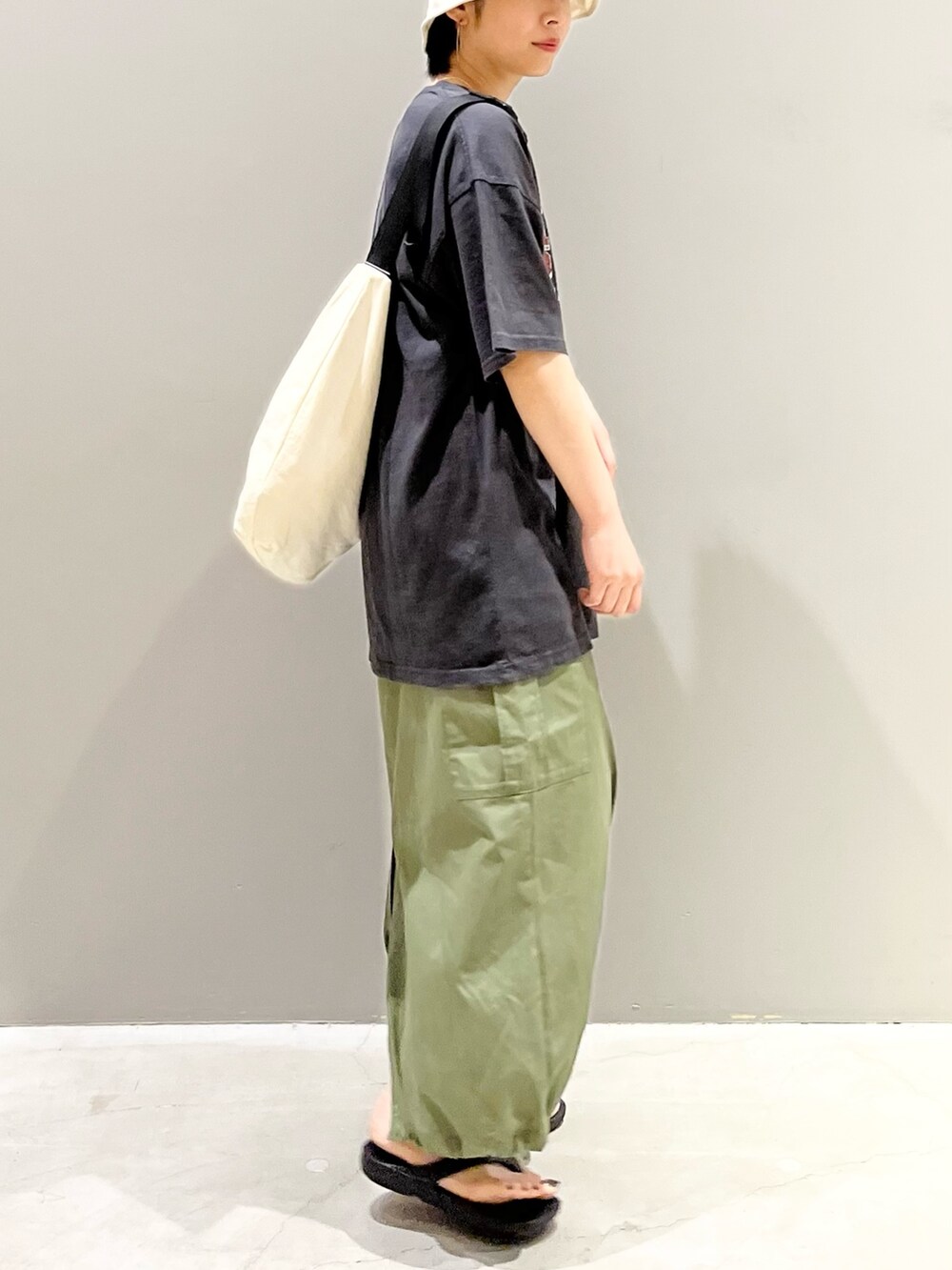 グレー系のTシャツ/カットソー、ホワイト系のショルダーバッグ、グリーン系のスカートを着用したレディースの夏コーディネートの6枚目の写真