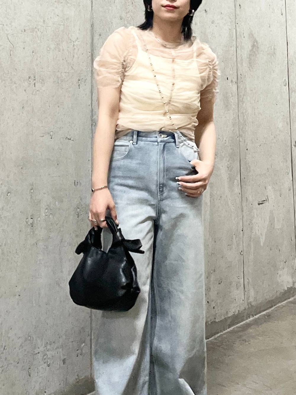 ホワイト系のキャミソール、ブルー系のデニムパンツ、ブラック系のサンダルを着用したレディースの夏コーディネートの4枚目の写真