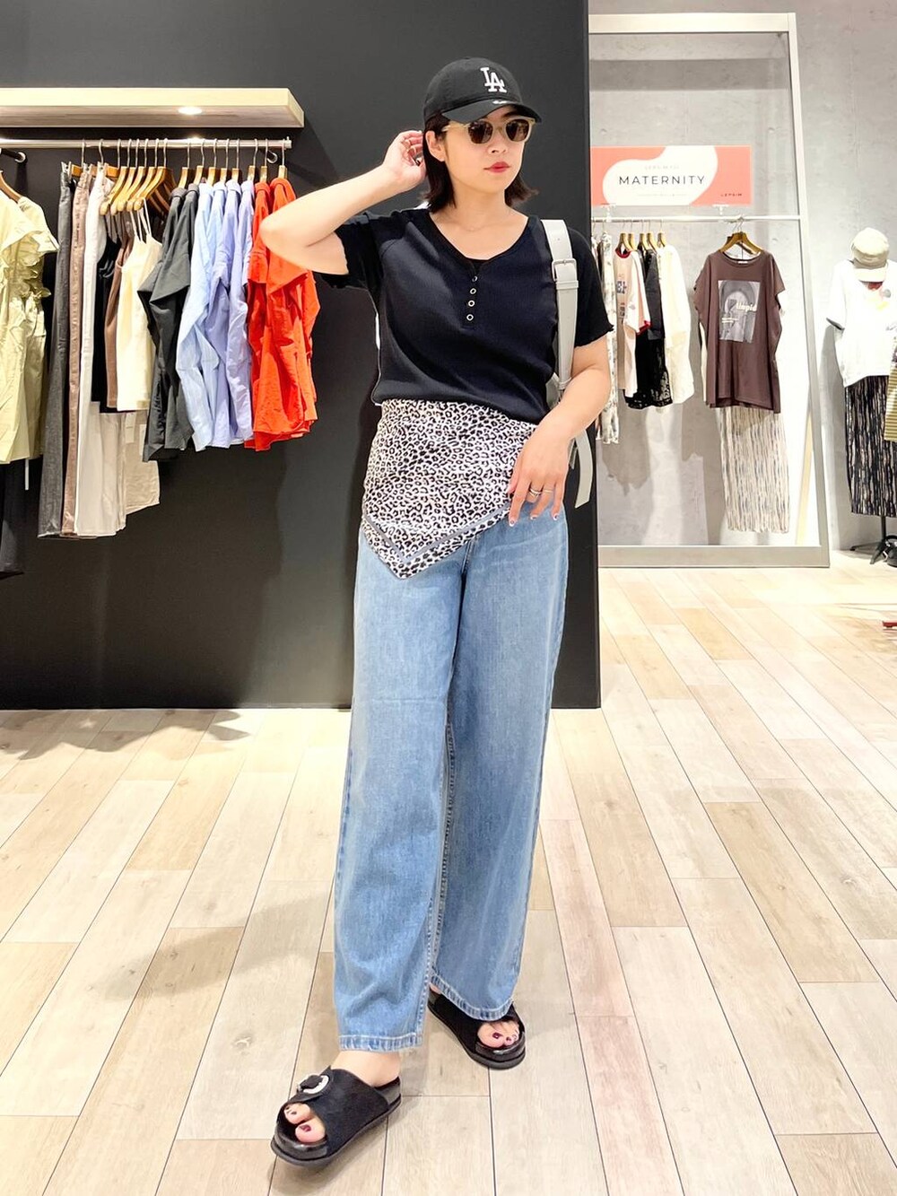 ブラック系のサンダル、ブルー系のデニムパンツ、グレー系のショルダーバッグを着用したレディースの夏コーディネートの6枚目の写真