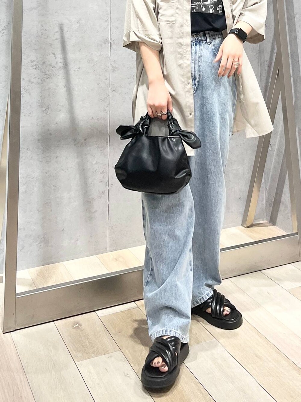 ブラック系のTシャツ/カットソー、ブラック系のサンダル、ブルー系のデニムパンツを着用したレディースの夏コーディネートの8枚目の写真