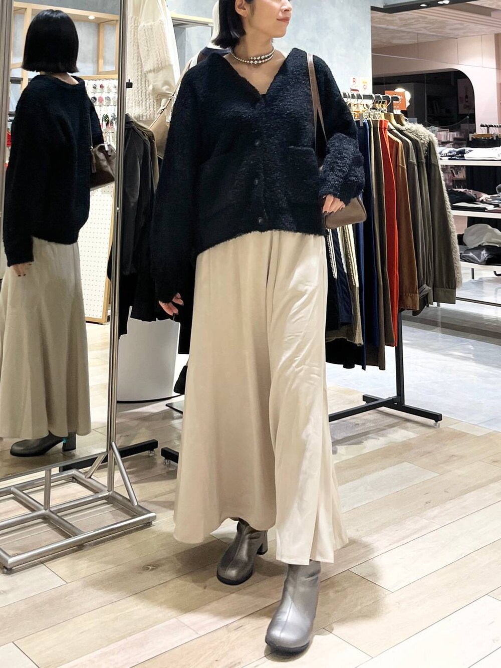 ブラウン系のボストンバッグ、ブラック系のスカート、その他のブーツを着用したレディースの秋コーディネートの2枚目の写真