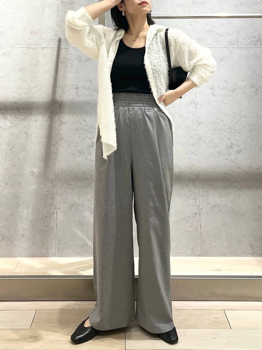 ブラック系のハンドバッグ、ホワイト系のシャツ/ブラウス、ブラック系のパンプスを着用したレディースの春コーディネートの2枚目の写真