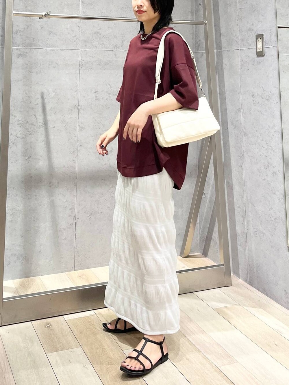 ホワイト系のショルダーバッグ、ブラック系のサンダル、レッド系のTシャツ/カットソーを着用したレディースの夏コーディネートの3枚目の写真