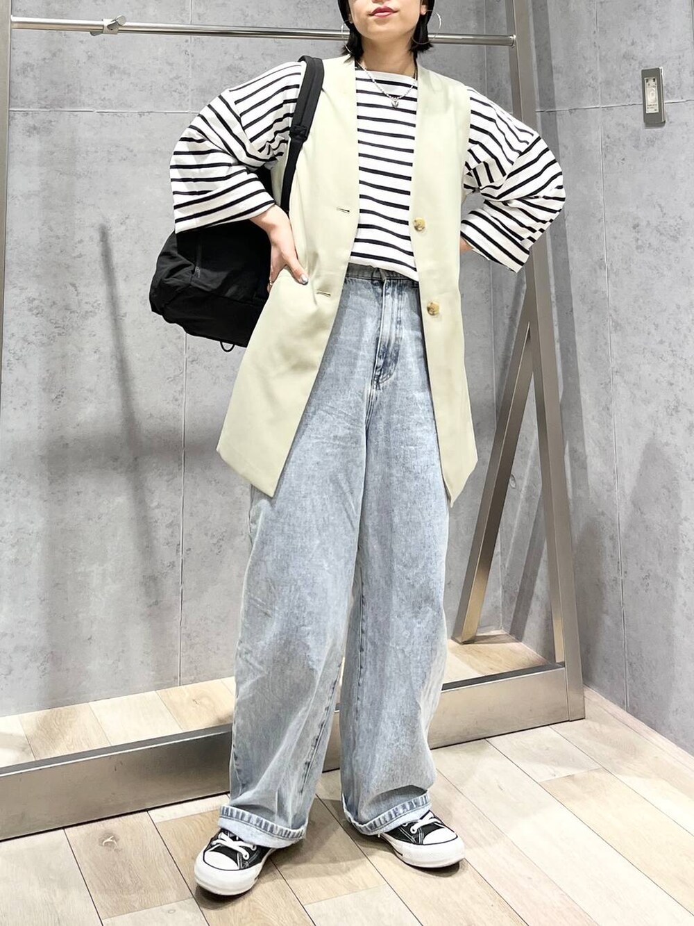 ブラック系のバックパック/リュック、ブルー系のTシャツ/カットソー、ブルー系のデニムパンツを着用したレディースの冬コーディネートの6枚目の写真