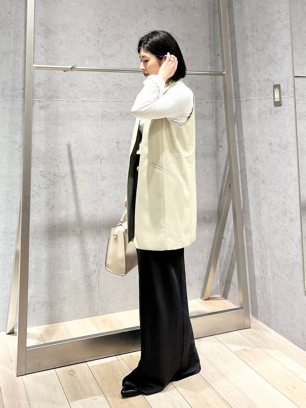 ホワイト系のTシャツ/カットソー、ブラック系のスカート、ホワイト系のショルダーバッグを着用したレディースの冬コーディネートの5枚目の写真