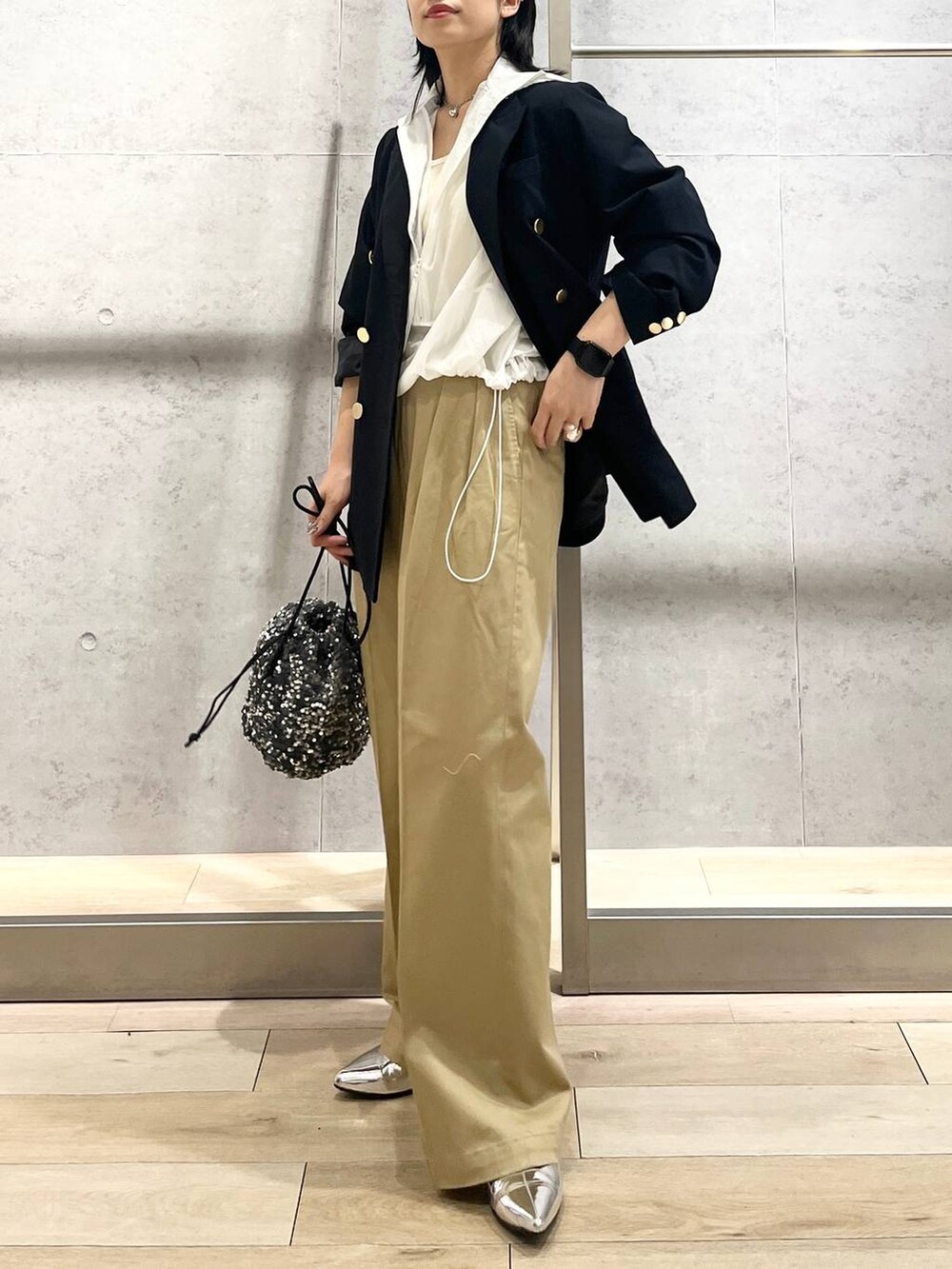 ブルー系のテーラードジャケット、ベージュ系のチノパンツ、ホワイト系のタンクトップを着用したレディースの夏コーディネートの6枚目の写真