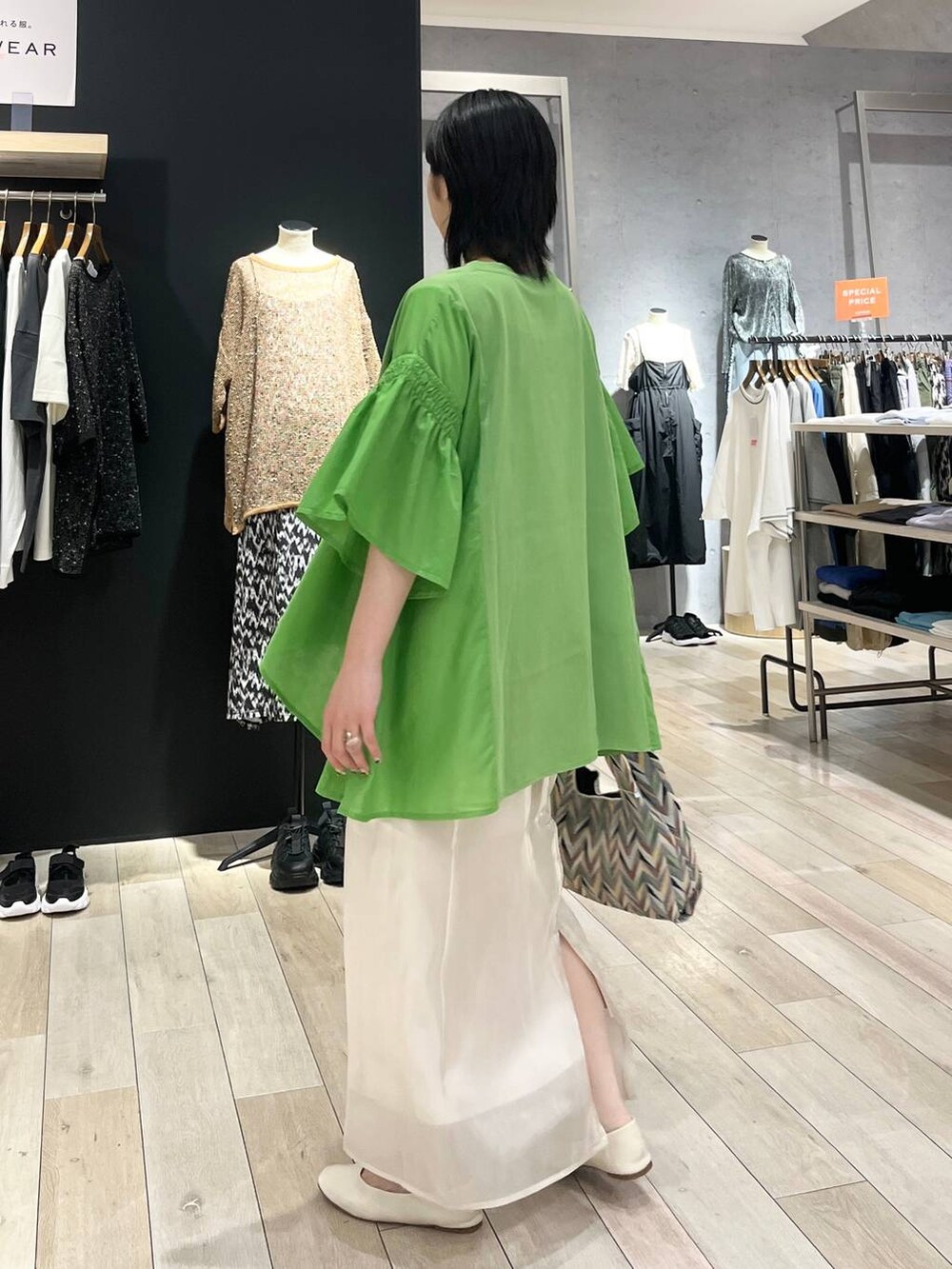 ホワイト系のハンドバッグ、ホワイト系のパンプス、ホワイト系のスカートを着用したレディースの春コーディネートの4枚目の写真
