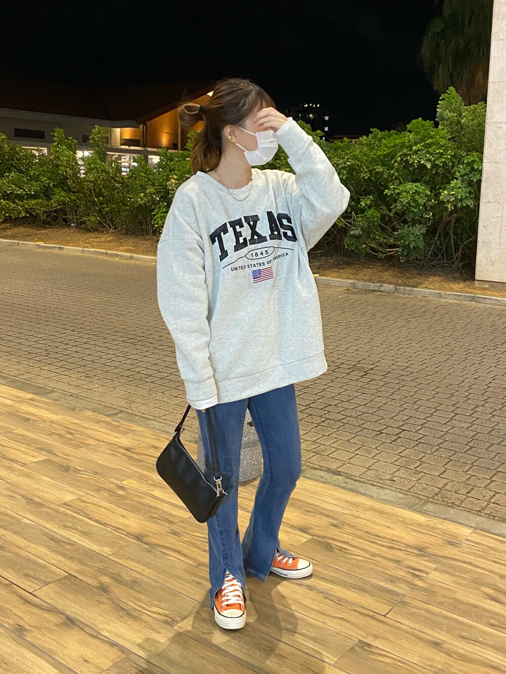 オレンジ系のスニーカーを着用したレディースの春コーディネートの2枚目の写真