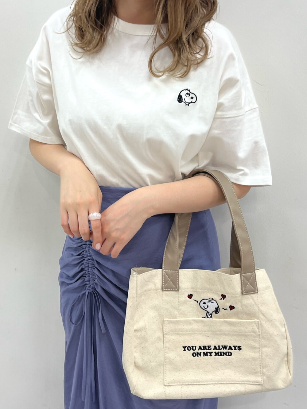 ホワイト系のTシャツ/カットソー、ブルー系のスカート、ホワイト系のバッグを着用したレディースの春コーディネートの3枚目の写真