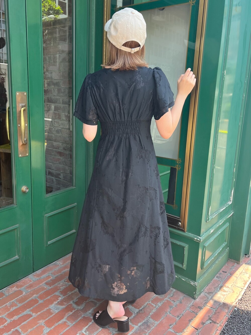 ブラック系のワンピース、ブラック系のサンダルを着用したレディースの春コーディネートの2枚目の写真